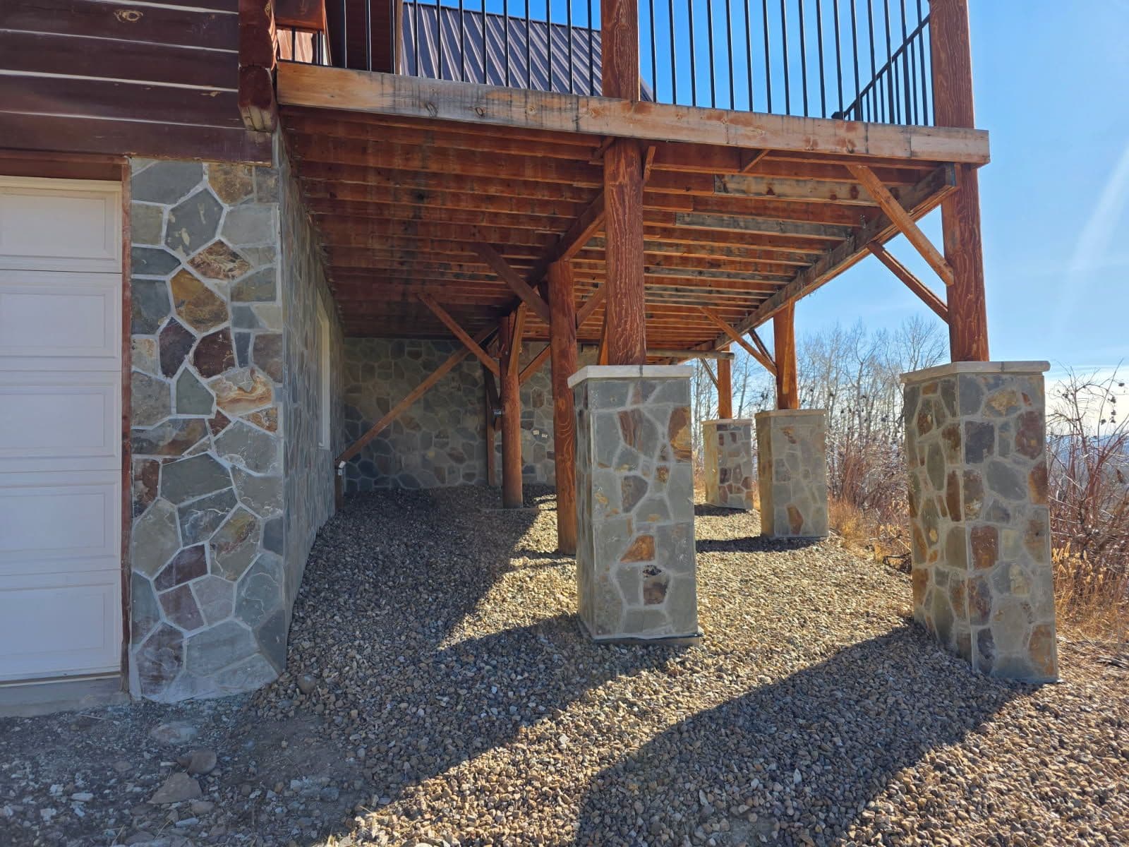 Enhanced Outdoor Living with Stone Columns and Wooden Deck image